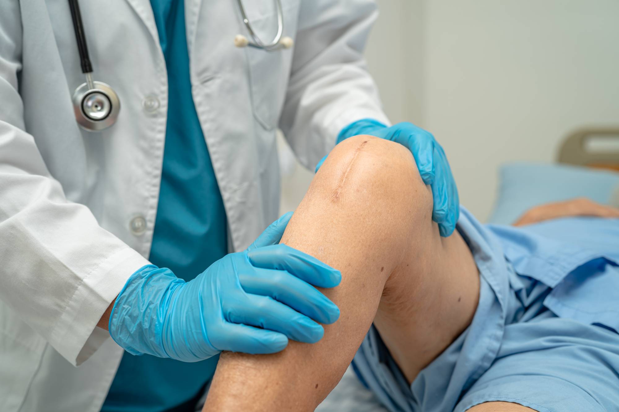 Doctor at CHI the, international medical clinic in Singapore examining elderly patient's sports injury