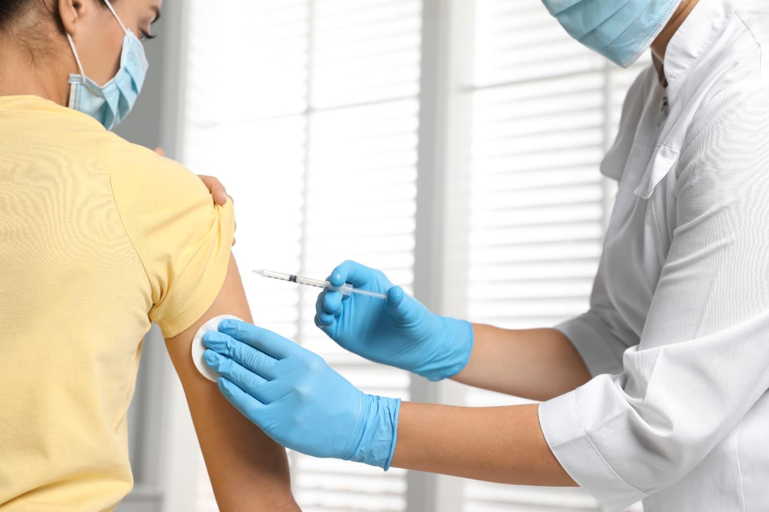 Doctor administering injection to patient in hospital