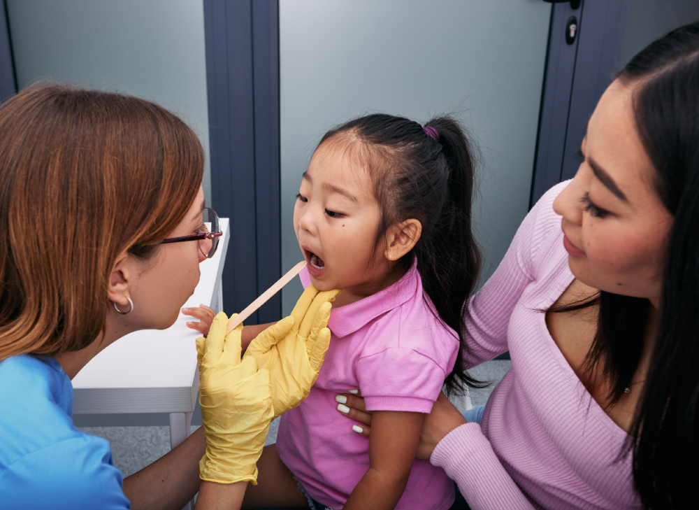 Doctor examining patient's throat at a Singapore GP clinic