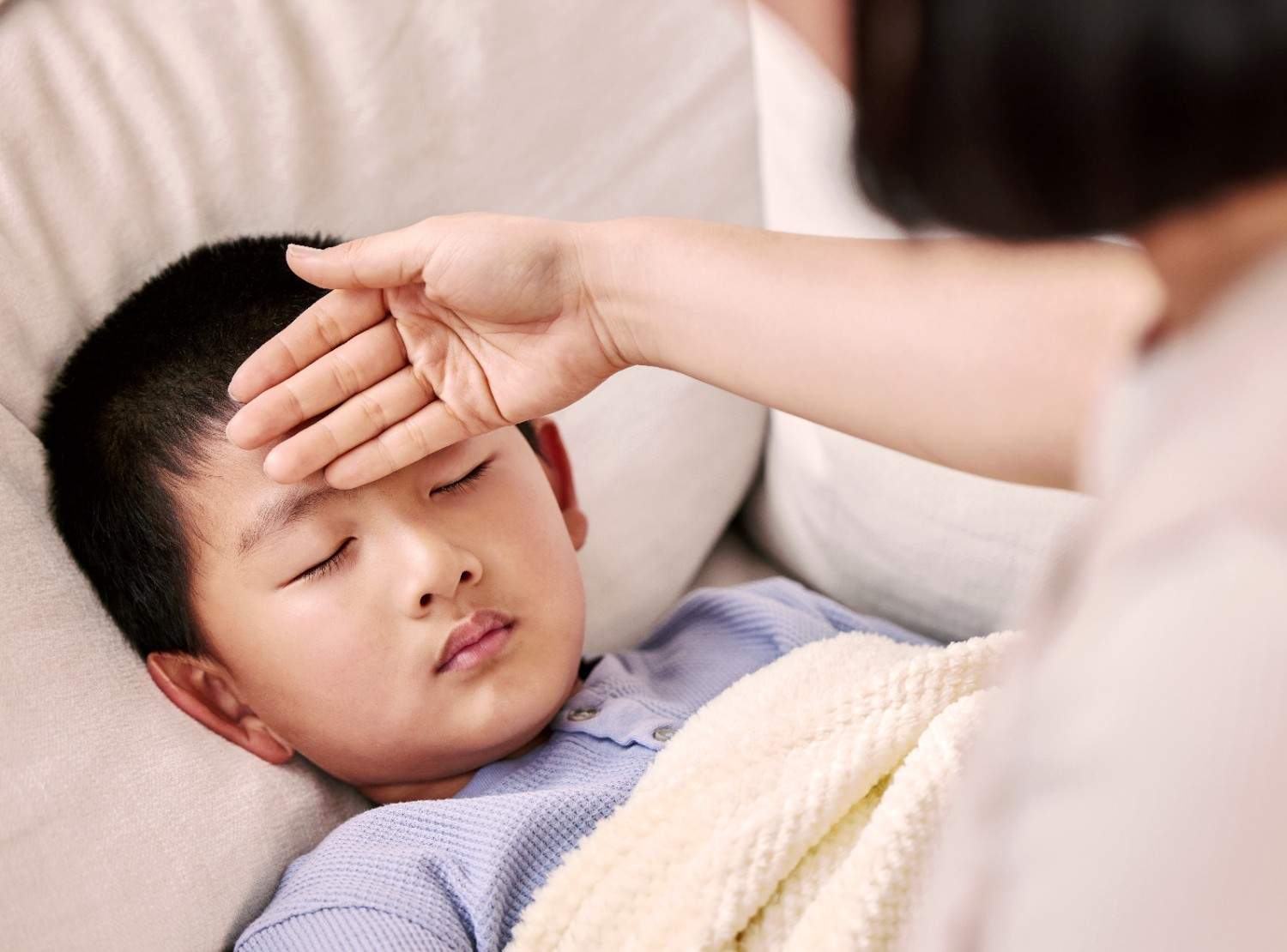 Mother checking child's fever temperature at home