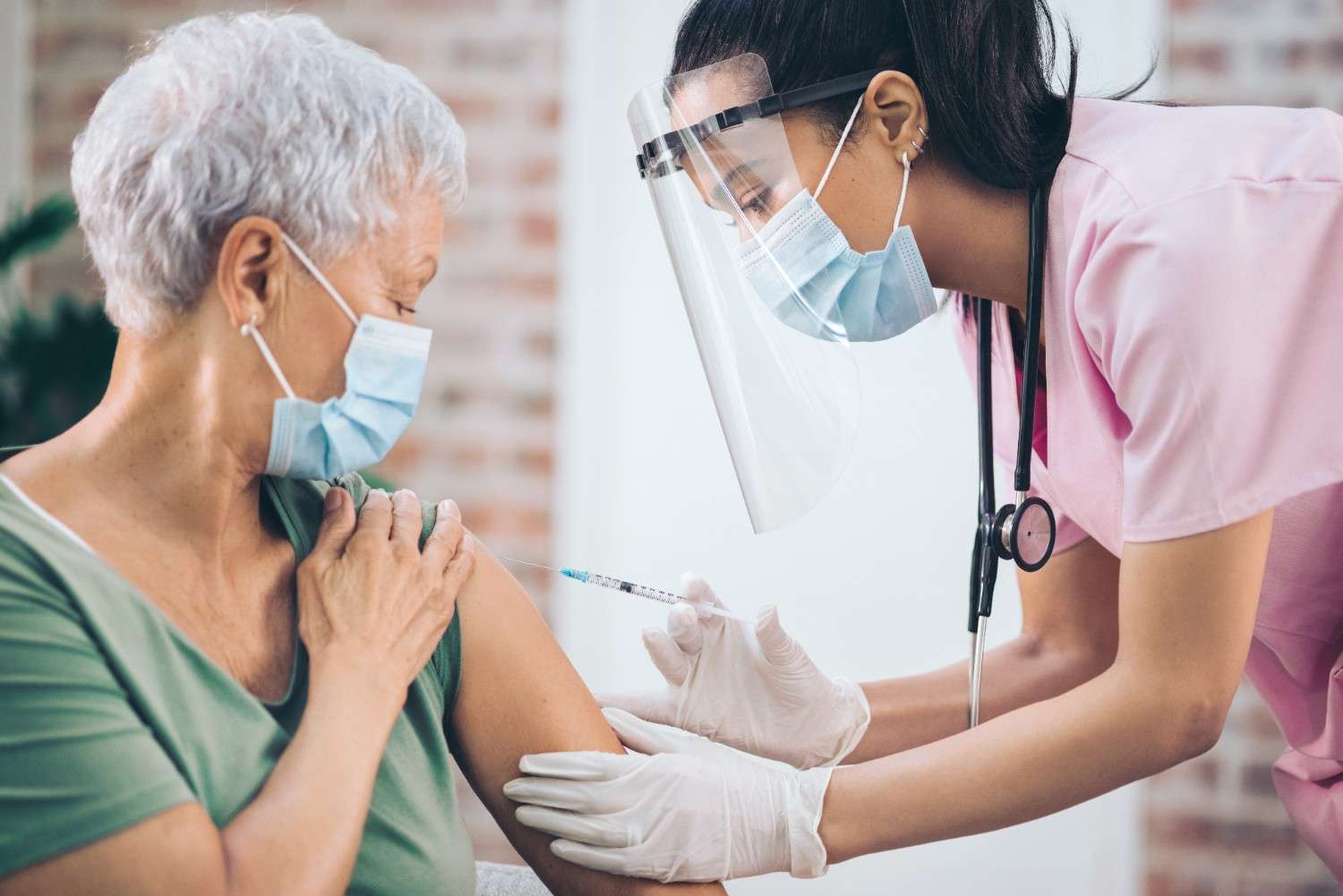 Nurse giving yellow fever vaccine to senior woman at travel clinic