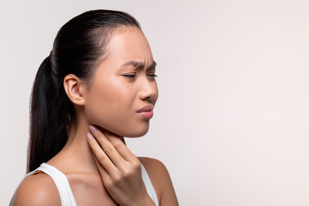 Woman experiencing sore throat symptoms in Singapore