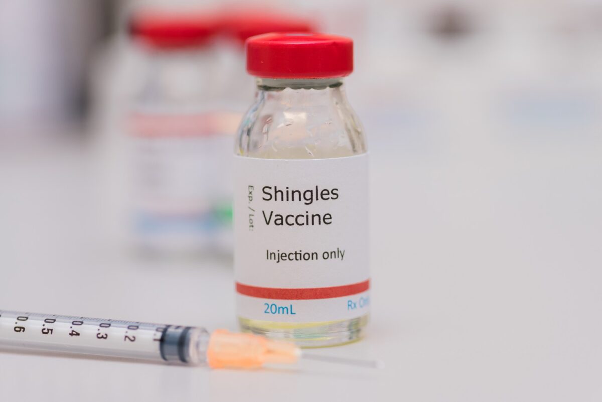 Doctor explaining shingles vaccine options to senior patient at CHI Health international medical clinic